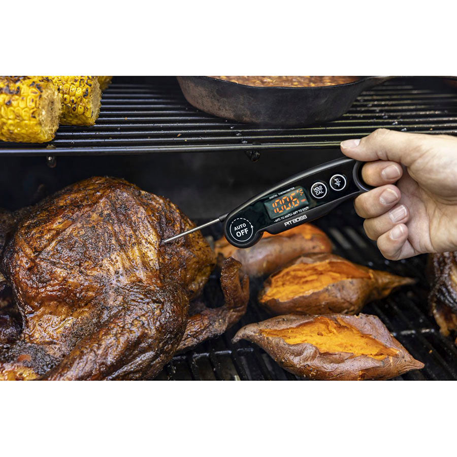Black RT808S digital meat thermometer measuring temperature on grilled meat and sweet potatoes.