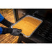 Aluminum tray with yellow food being placed in oven by gloved hands.