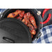 Black Pit Boss Dutch oven with chicken wings and red peppers.