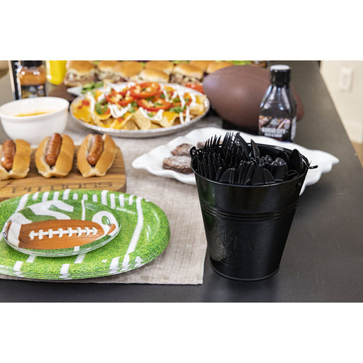 Black plastic bucket with black utensils, football-themed party setup.