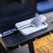 Silver Pit Boss spatula with perforated head, resting on white holder on black grill surface.