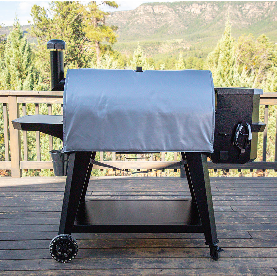 Gray cover on black pellet grill with wheels, outdoor setting.