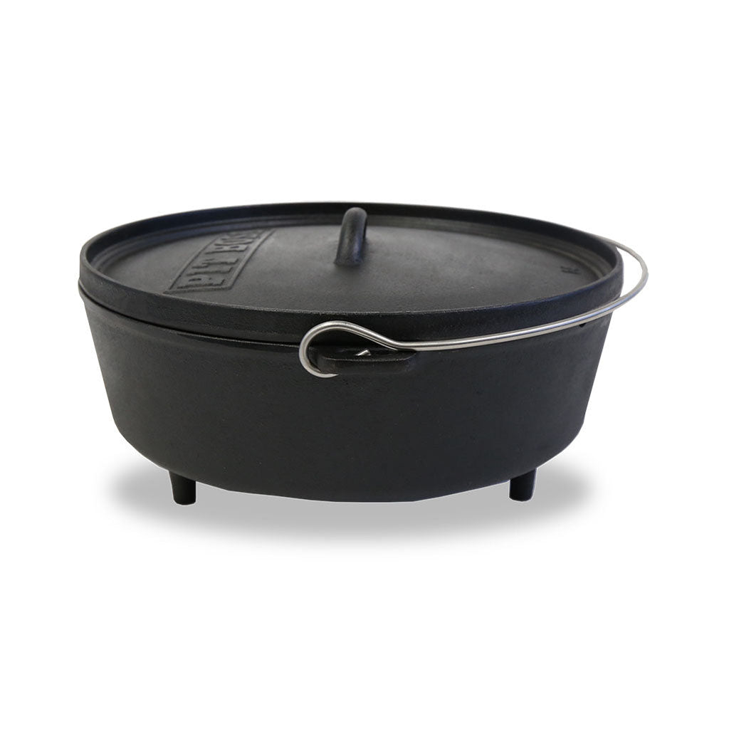 Black cast iron Dutch oven with lid and handles.