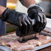 Black meat tenderizer tool being used on raw chicken.