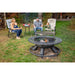 Round metal outdoor fire pit with grill grate, black finish, set on grass with people seated around it.