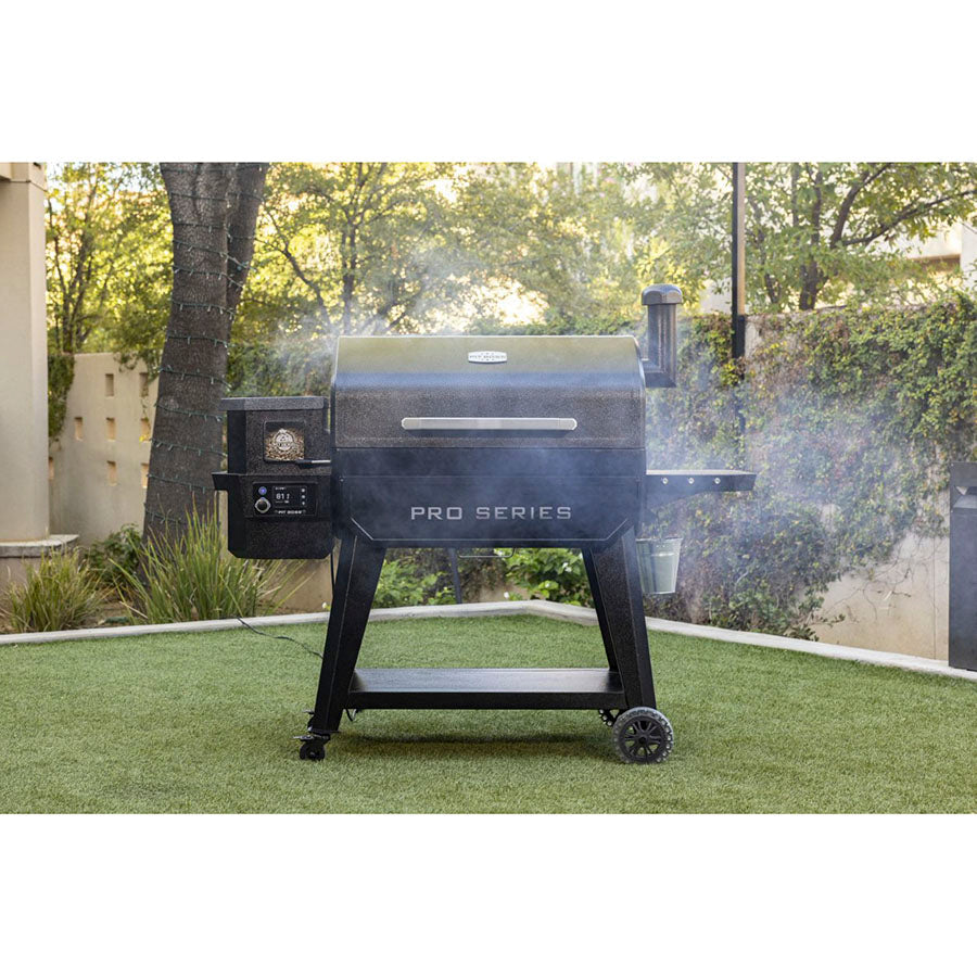 Black Pro Series pellet grill with smoking chimney on grass.