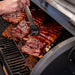 Grilled ribs with barbecue sauce on a black grill.