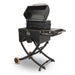 Portable black pellet grill with folding legs, side shelf, control knob, and wheels for easy transport.