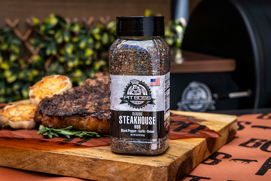Pit Boss Classic Steakhouse Rub in front of a grilled steak on a cutting board 