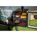 Outdoor multi-level smoker with cheese, nuts, and meat cooking inside.