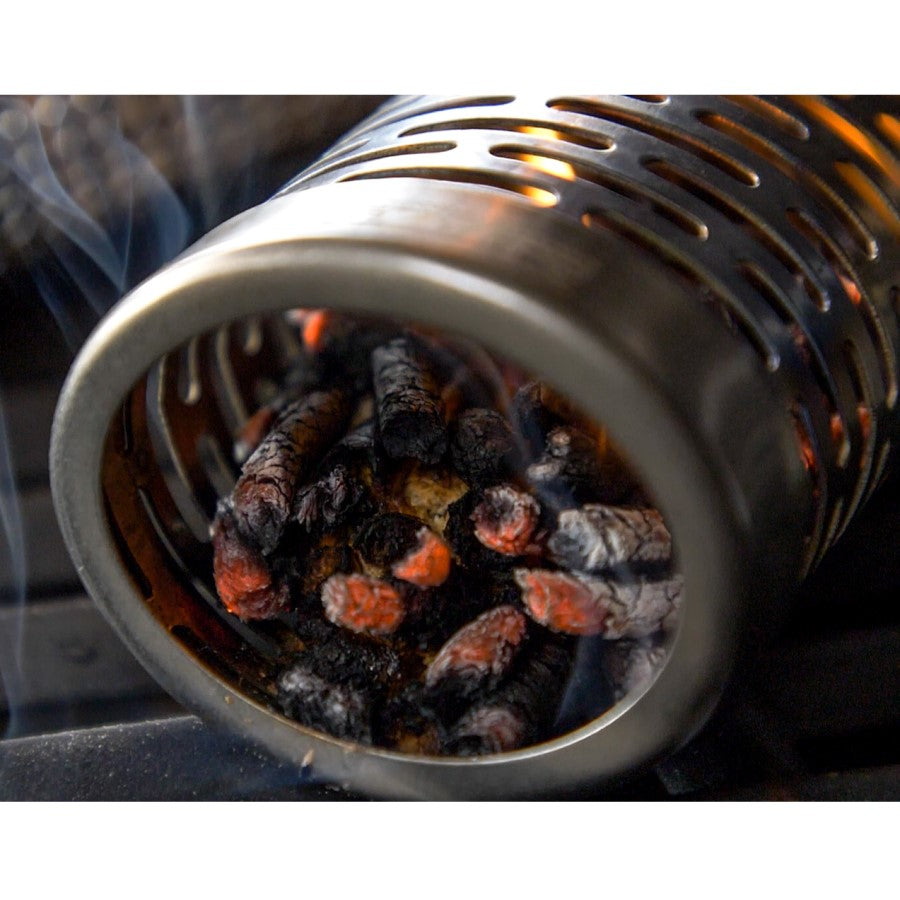 Stainless steel smoker tube filled with burning wood chips, emitting smoke for grilling or BBQ flavor enhancement.