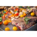 Grilled steak with rosemary, cherry tomatoes, and vegetables.