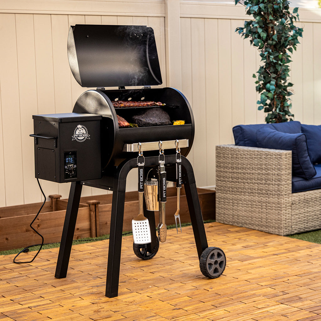 Pit Boss Carbon Series 500 wood pellet grill shown from side angle with lid open, revealing cooking racks