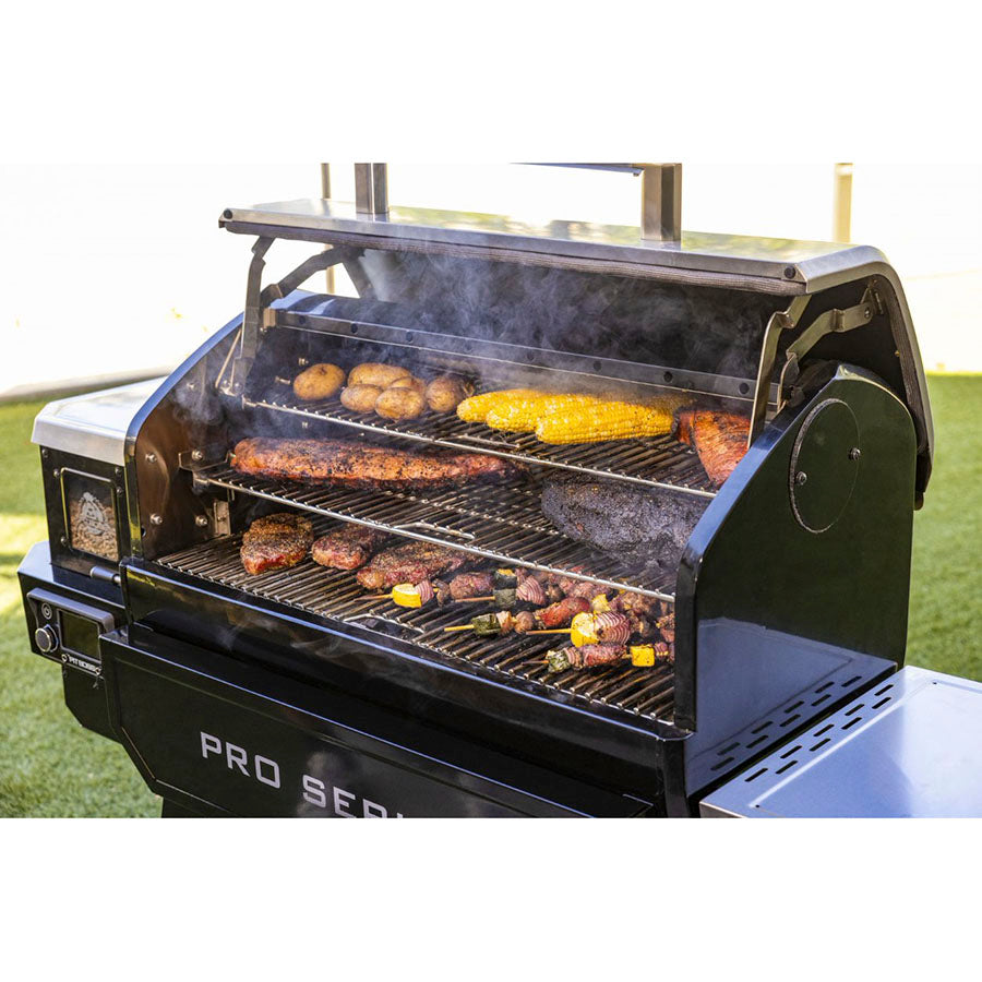 Black Pro Series multi-level grill with various meats and vegetables cooking.