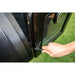 Black vehicle door handle with hand gripping it.