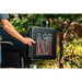 Black electric smoker with glass window showing sausages inside, thermometer visible.