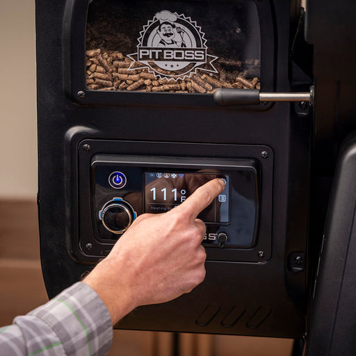 Up close of digital control board. Grill in a backyard setting.