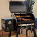 Pit Boss Carbon Series 700 wood pellet grill, zoomed-in view with lid open showing food cooking on the grates
